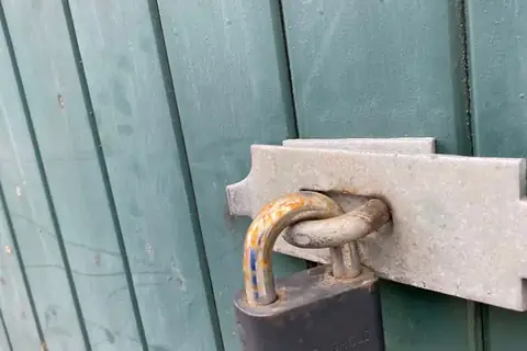 Symbolbild: Tür mit Vorhängeschloss